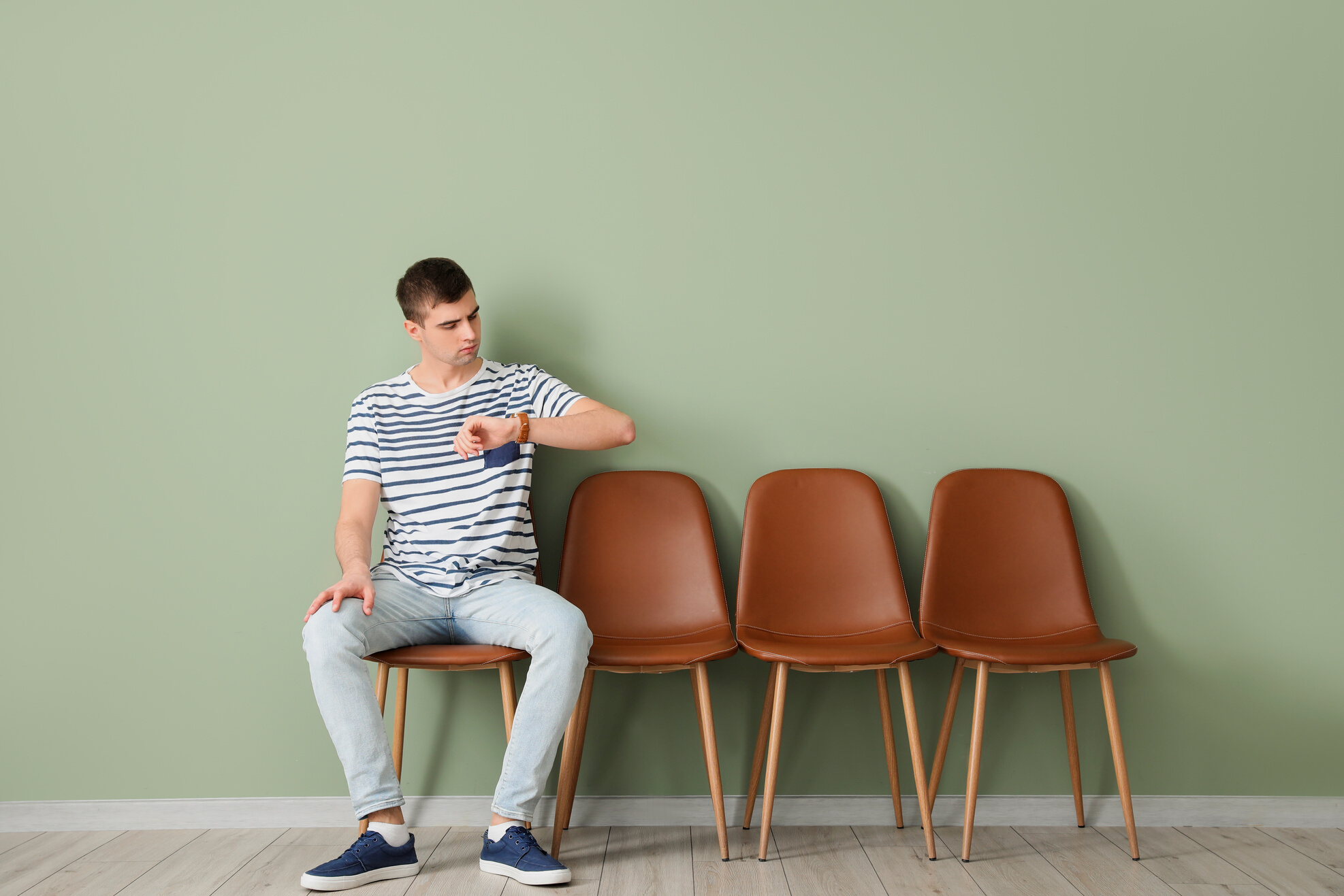 Young Man Sitting on Chair while Waiting for His Turn